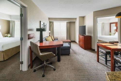 um quarto de hotel com uma secretária e uma cama em Residence Inn Burlington Colchester em Burlington