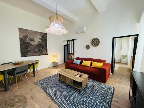 een woonkamer met een rode bank en een tafel bij Pépite Bastiaise Place du Marché in Bastia