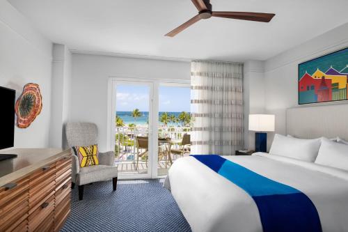 a hotel room with a bed and a view of the beach at Marriott's Aruba Ocean Club in Palm-Eagle Beach