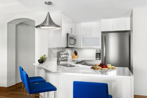 a kitchen with white cabinets and blue chairs at Marriott's Aruba Ocean Club in Palm-Eagle Beach