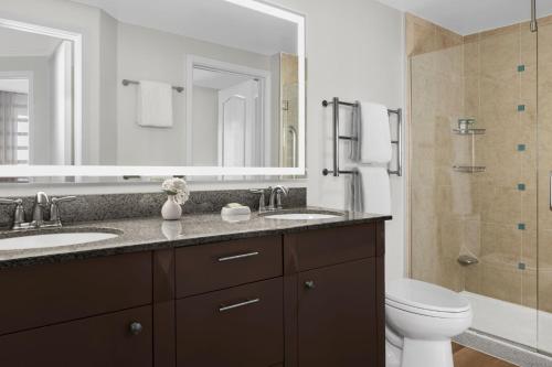 a bathroom with two sinks and a toilet and a mirror at Marriott's Aruba Ocean Club in Palm-Eagle Beach