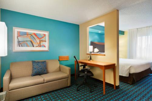 a hotel room with a bed and a couch and a desk at Fairfield Inn & Suites Dallas Mesquite in Mesquite