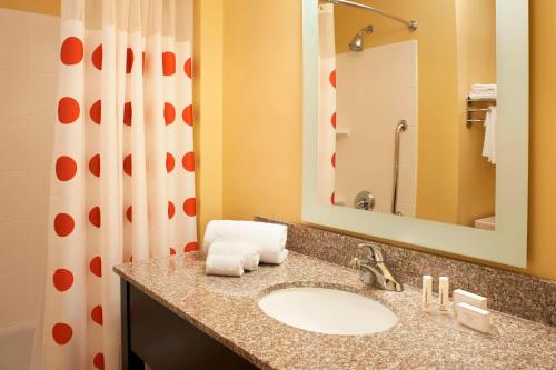 a bathroom with a sink and a shower with a mirror at TownePlace Suites by Marriott Saginaw in Saginaw