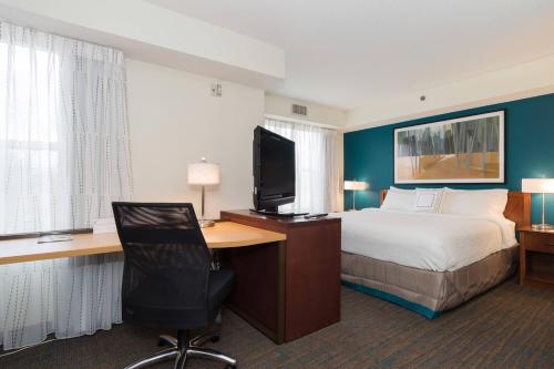 a hotel room with a bed and a desk with a television at Residence Inn by Marriott Lake Norman in Huntersville