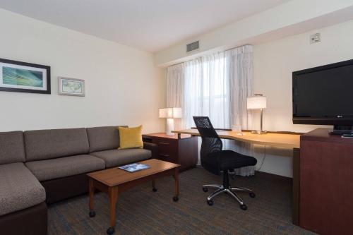 a hotel room with a couch and a desk with a computer at Residence Inn by Marriott Lake Norman in Huntersville
