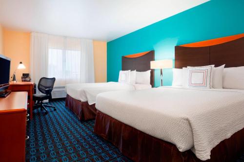 a hotel room with two beds and a television at Sonesta Essential Houston Energy Corridor in Houston