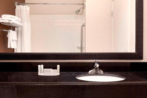 a bathroom with a sink and a large mirror at Sonesta Essential Houston Energy Corridor in Houston