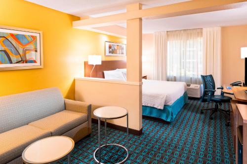 a hotel room with a bed and a couch at Fairfield Inn & Suites by Marriott Atlanta Perimeter Center in Atlanta