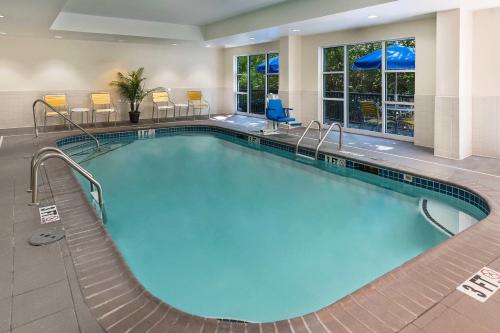een groot zwembad in een hotelkamer met stoelen en tafels bij Fairfield Inn & Suites by Marriott Atlanta Perimeter Center in Atlanta