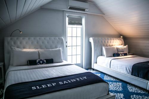 a bedroom with two beds and a window at The Saint Hotel Key West, Autograph Collection in Key West