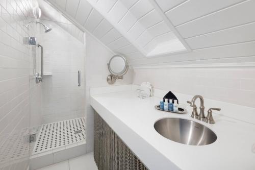 a white bathroom with a sink and a shower at The Saint Hotel Key West, Autograph Collection in Key West