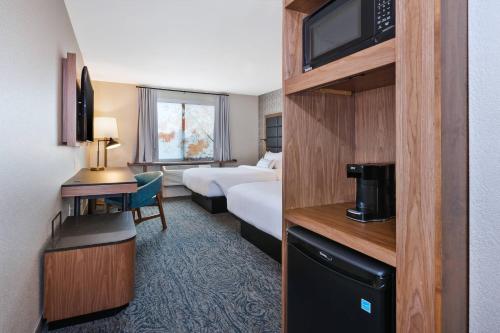 a hotel room with a bed and a television at Fairfield Inn & Suites by Marriott Kalamazoo in Kalamazoo