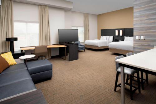 Cette chambre comprend 2 lits et une télévision. dans l'établissement Residence Inn by Marriott Lubbock Southwest, à Lubbock