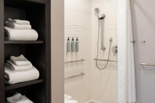 a bathroom with a shower and a sink and towels at Residence Inn by Marriott Wilkes-Barre Arena in Wilkes-Barre