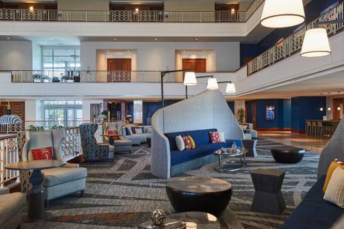 a lobby with couches and tables and a staircase at Renaissance Concourse Atlanta Airport Hotel in Atlanta