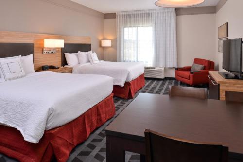 a hotel room with two beds and a desk at TownePlace Suites by Marriott Gillette in Gillette