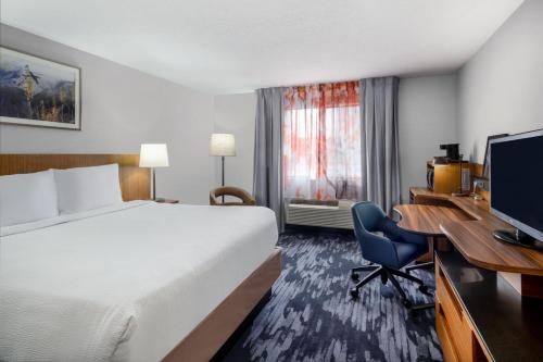 a hotel room with a bed and a desk with a computer at Fairfield Inn & Suites by Marriott Salt Lake City Downtown in Salt Lake City