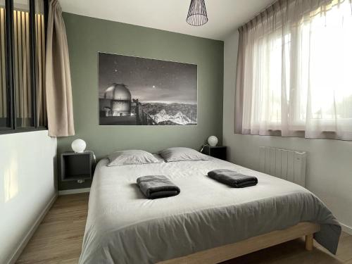 een slaapkamer met een groot bed en 2 handdoeken bij Appartement - Le Petit Loft - in Tarbes