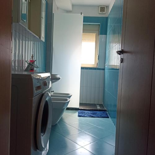 Un baño con inodoro y lavadora. en VLORE 1+1, en Vlorë