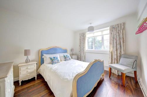 a bedroom with a bed and a chair and a window at 2 bed flat - SW London with parking in Teddington