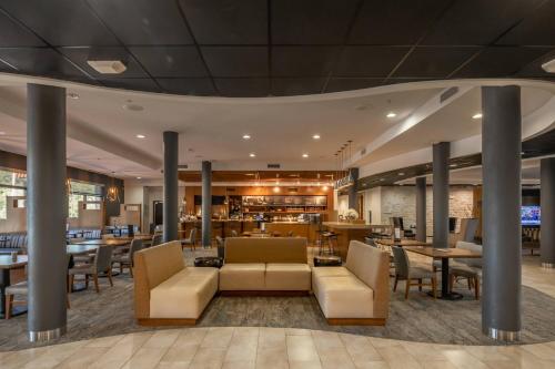 a lobby of a hotel with tables and chairs at Courtyard by Marriott New Braunfels River Village in New Braunfels