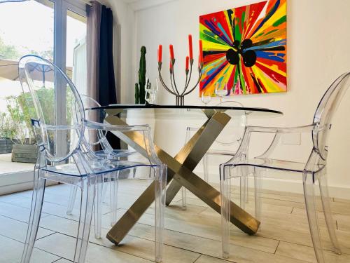 a dining room with a glass table and two chairs at Les Lodges de Saint Cassien in Montauroux