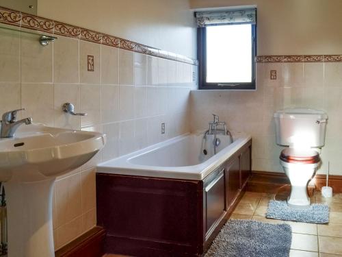 a bathroom with a tub and a sink and a toilet at Littlewood Barn - Ukc3737 in Bawdeswell