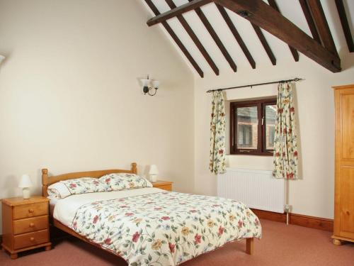 a bedroom with a bed and a window at Littlewood Barn - Ukc3737 in Bawdeswell