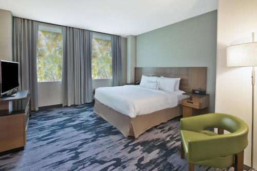 Habitación de hotel con cama, silla y TV en Fairfield Inn & Suites by Marriott Milwaukee Downtown en Milwaukee