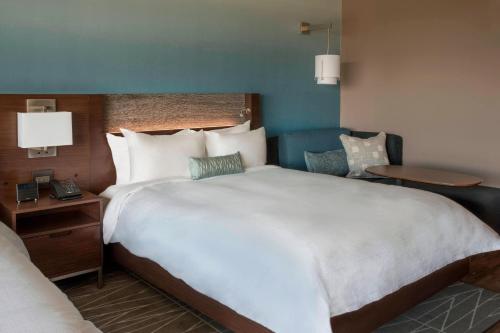 a hotel room with a large bed and a chair at Buffalo Marriott at LECOM HARBORCENTER in Buffalo