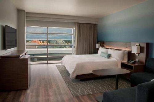 a hotel room with a bed and a large window at Buffalo Marriott at LECOM HARBORCENTER in Buffalo