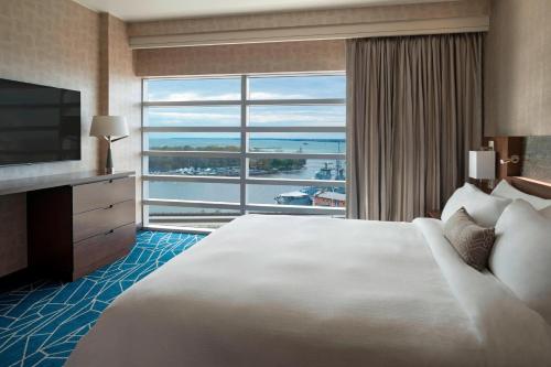 a hotel room with a large bed and a large window at Buffalo Marriott at LECOM HARBORCENTER in Buffalo