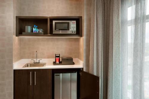 a kitchen with a sink and a microwave at Buffalo Marriott at LECOM HARBORCENTER in Buffalo