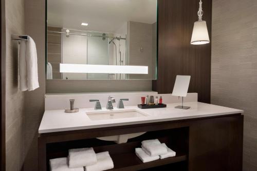 a bathroom with a sink and a mirror at Buffalo Marriott at LECOM HARBORCENTER in Buffalo