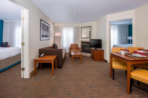 um quarto de hotel com uma cama e uma sala de estar em Residence Inn Boise West em Boise