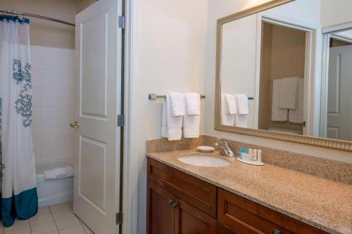 Residence Inn Boise West في بويز: حمام مع حوض ومرآة