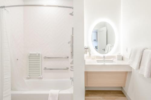 Baño blanco con lavabo y espejo en TownePlace Suites by Marriott Dallas Rockwall en Rockwall
