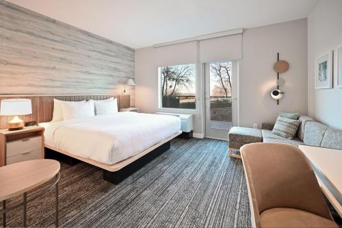 um quarto de hotel com uma cama e um sofá em TownePlace Suites by Marriott Dallas Rockwall em Rockwall