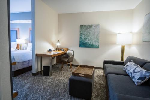 una sala de estar con sofá y escritorio en una habitación de hotel en SpringHill Suites by Marriott Winston-Salem Hanes Mall en Winston-Salem