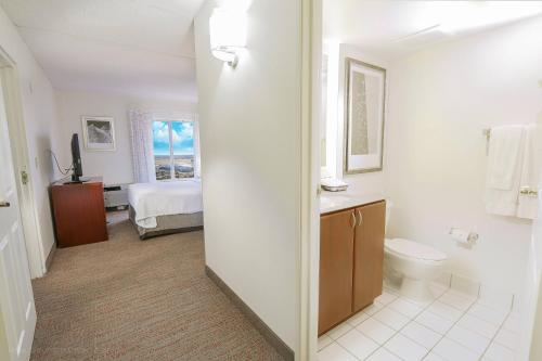 ein Bad mit einem WC und ein Schlafzimmer mit einem Bett in der Unterkunft Residence Inn Fort Worth Alliance Airport in Roanoke