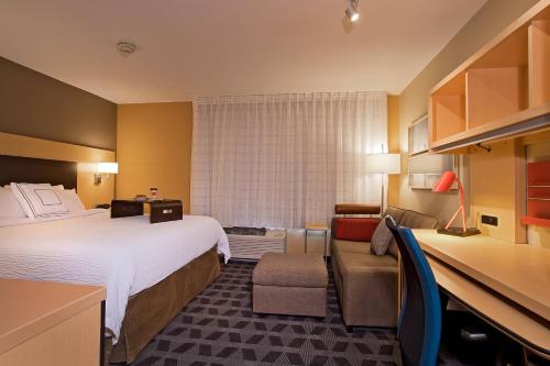 una camera d'albergo con un grande letto e un divano di TownePlace Suites by Marriott Dodge City a Dodge City