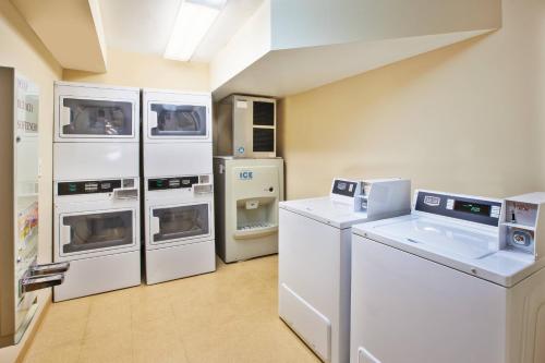 a kitchen with white appliances in a room at TownePlace Suites Detroit Dearborn in Dearborn