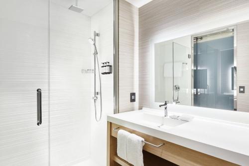 uma casa de banho com um lavatório e um chuveiro em AC Hotel by Marriott Dallas Frisco em Frisco