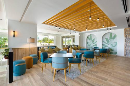 a dining room with blue chairs and tables at Courtyard by Marriott Cancun Airport in Cancún