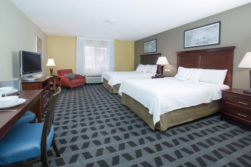 a hotel room with two beds and a television at TownePlace Suites Pocatello in Pocatello