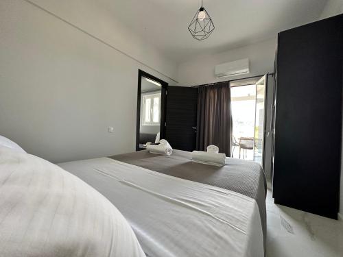 ein großes weißes Bett in einem Zimmer mit Fenster in der Unterkunft Nisos Family House in Perama