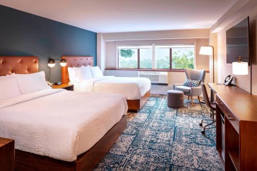 Habitación de hotel con 2 camas y escritorio en Four Points by Sheraton Norwood Conference Center en Norwood