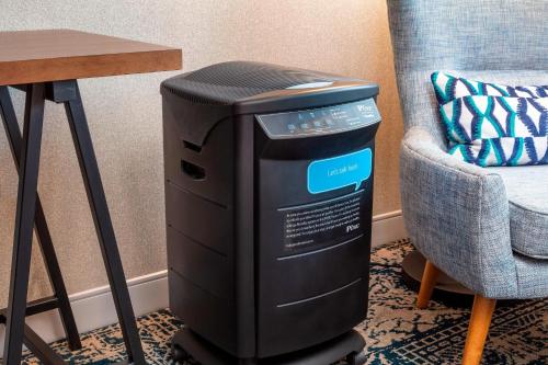 a computer sitting on a floor next to a chair at Four Points by Sheraton Norwood Conference Center in Norwood