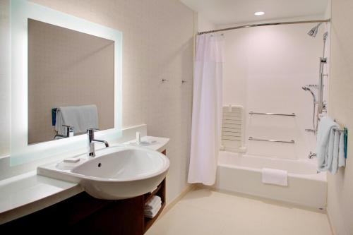 SpringHill Suites by Marriott Augusta في أوغوستا: حمام أبيض مع حوض ودش