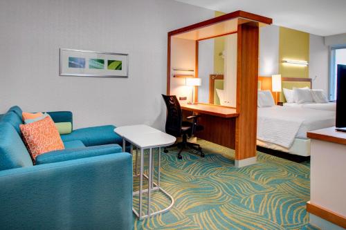 um quarto de hotel com um sofá e uma cama em SpringHill Suites by Marriott Augusta em Augusta